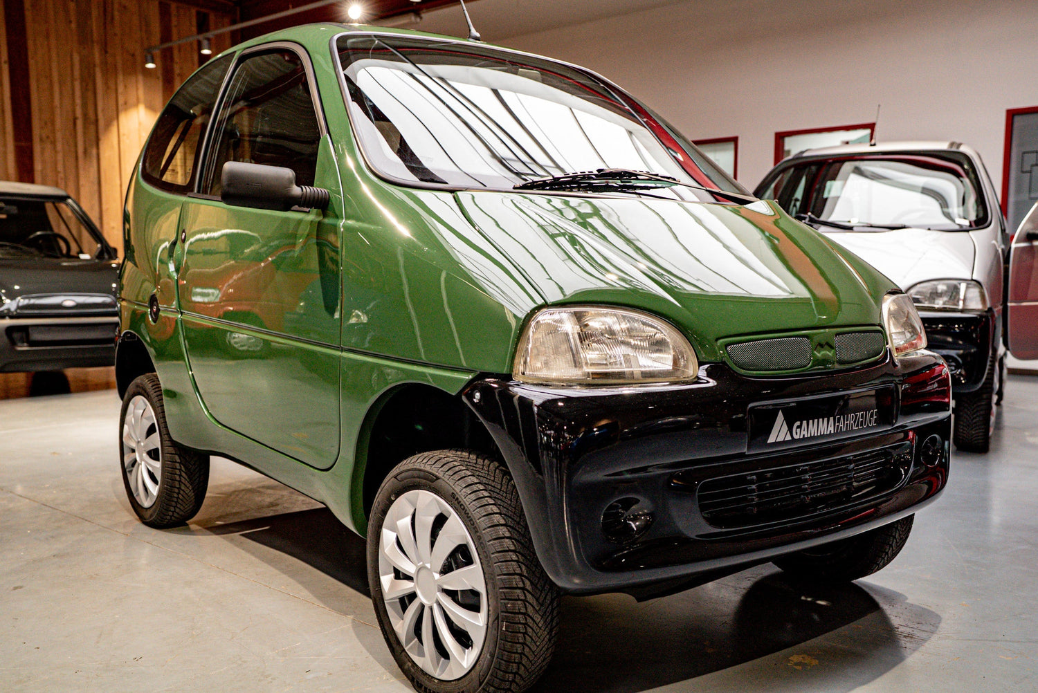 Klassischer Krankenfahrstuhl nach §76 FeV mit geschlossener Kabine in einer Ausstellung bei GAMMA Fahrzeuge – führerscheinfrei nutzbares Kabinenfahrzeug bis 25 km/h.